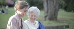 daughter explaining elderly mother how using smartphone